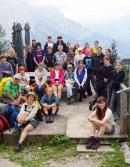 Eine Gruppe von Kindern sitzt zusammen vor einem Bergpanorama